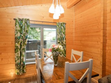 A dining room with a wooden table and chairs at Oak Lodge Pennington near Ulverston
