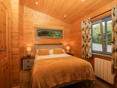 A bedroom with a double bed and window at Oak Lodge in Pennington near Ulverston