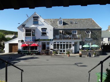 A fish and chips takeaway with outdoor seating and umbrellas at Seal Cottage in Mortehoe