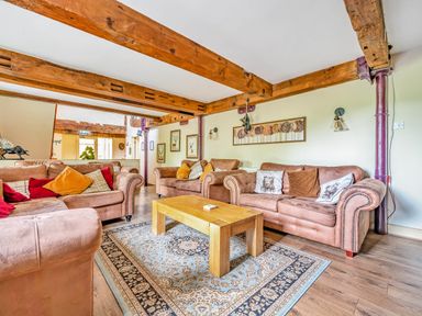 A sitting room with three couches a wooden coffee table and wooden ceiling beams at Eden Mill Millers Beck in Kendal