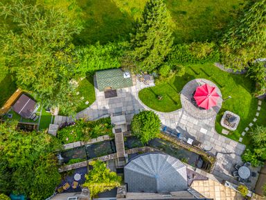 An aerial view of a garden with patio areas a red umbrella seating and a small stream at Eden Mill Millers Beck Kendal