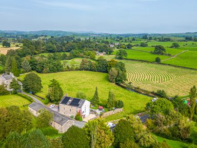 A rural landscape with fields trees and buildings at Eden Mill Millers Beck in Kendal