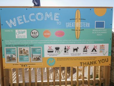 A welcome sign at Great Western Surfing Beach with rules and event information in Newquay
