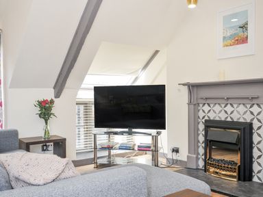 A living room with a television and sofa at Beach Retreat Looe