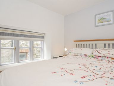 A bedroom with a bed and window at Beach Retreat in Looe