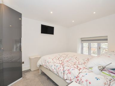 A bedroom with a bed and wardrobe at Beach Retreat in Looe