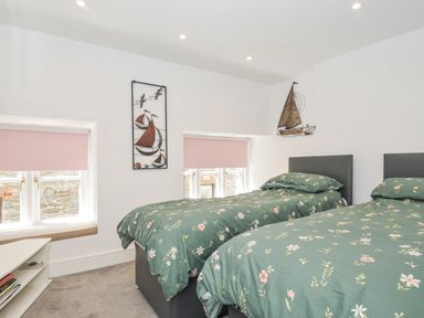 A bedroom with two beds and decor at Beach Retreat in Looe
