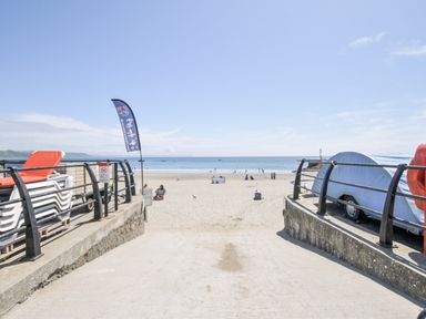 A beach with chairs and a caravan at Beach Retreat in Looe