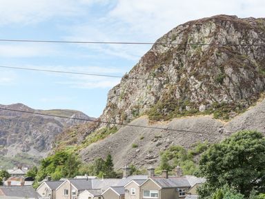A mountain with rocky slopes above houses in a residential area at Garreg Ddu in Blaenau Ffestiniog