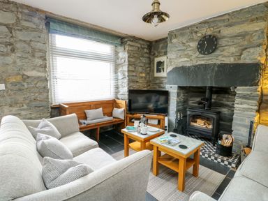 A living room with a sofa and fireplace at Garreg Ddu in Blaenau Ffestiniog