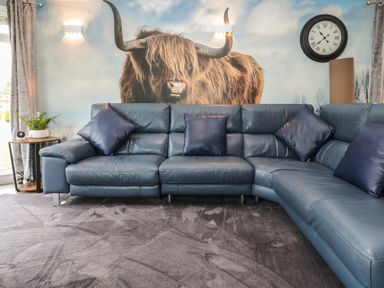 A living room with a blue sofa and wall art at 16 Badgers Retreat Richmond