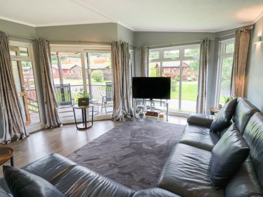 A living room with a television and sofa at 16 Badgers Retreat in Richmond
