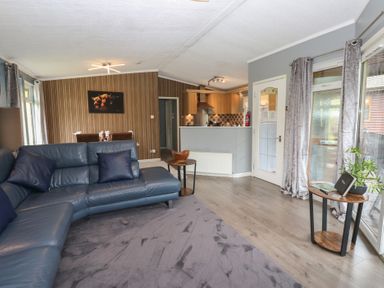 A living room with a couch and dining area at 16 Badgers Retreat in Richmond