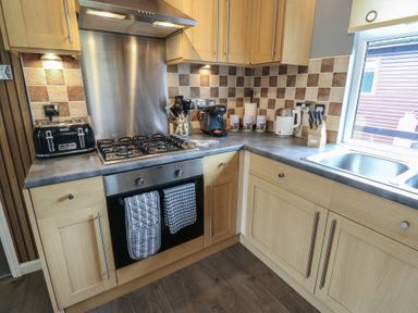A kitchen with cabinets, stove, and sink at 16 Badgers Retreat in Richmond