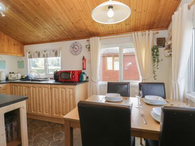 A kitchen with a dining table and chairs at The Cedars in South Lakeland Leisure Village