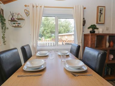 A dining room with a table set for meals at The Cedars in South Lakeland Leisure Village