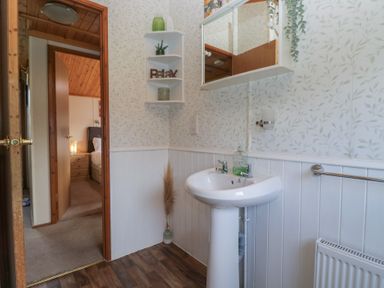 A bathroom with a sink and mirror at The Cedars in South Lakeland Leisure Village