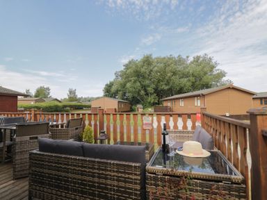 A seating area on a deck with a table and chairs at The Cedars South Lakeland Leisure Village