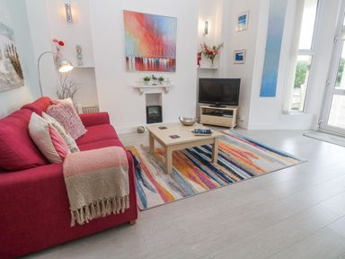 A living room with a sofa and television at Beachcomber in Marazion