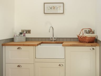 A kitchen sink with wooden countertops a cleaning caddy and a wicker basket at Shepherd's Rest in Montgomery
