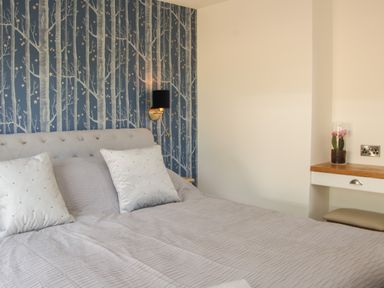 A bedroom with a bed and two pillows and a bedside table with a lamp and a desk with a flower at Shepherd's Rest in Montgomery