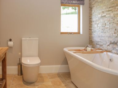 A bathroom with a toilet next to a bathtub under a window at Shepherd's Rest in Montgomery