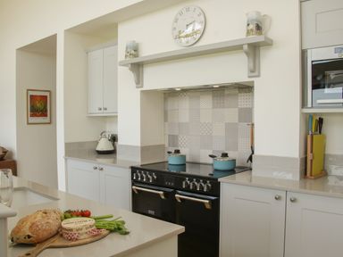 A kitchen with a black stove two light blue pots and a wooden board with bread and vegetables at Shepherd's Rest in Montgomery