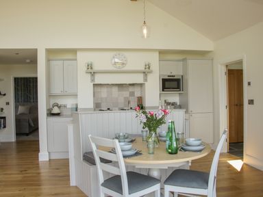 A kitchen and dining area with a round table set for four and built in cabinets at Shepherds Rest in Montgomery