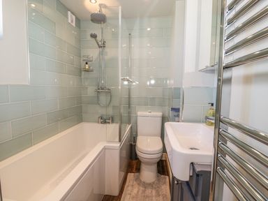 A bathroom with a bathtub shower combination toilet sink and towel radiator at Emblestones in Embleton