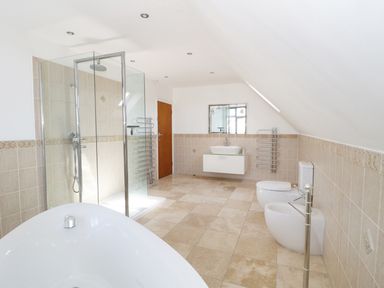 A bathroom with a freestanding bathtub shower cubicle toilet bidet and sink at 20 Ulwell Road in Swanage