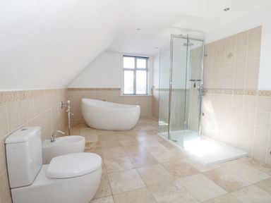 A bathroom with a toilet bidet bathtub and glass shower enclosure at 20 Ulwell Road in Swanage