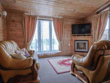 A living room with leather furniture and a television at The Cabin at East Hill Pride Four Elms Hill Nr. Sidmouth