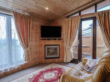 A snug with a television and fireplace at The Cabin at East Hill Pride Four Elms Hill Nr. Sidmouth