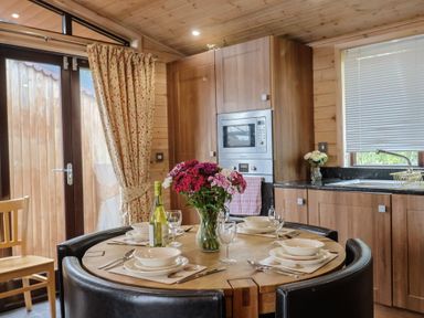 A kitchen with a table set for dining at The Cabin at East Hill Pride Four Elms Hill Nr. Sidmouth
