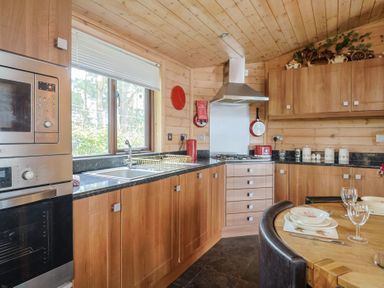A kitchen with appliances and dining furniture at The Cabin at East Hill Pride Four Elms Hill Nr. Sidmouth