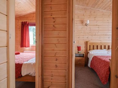A bedroom with two beds and a window at The Cabin at East Hill Pride in Four Elms Hill Nr. Sidmouth
