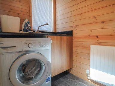 A laundry room with a washing machine and sink at The Cabin at East Hill Pride in Four Elms Hill Nr. Sidmouth