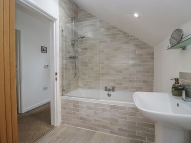 A bathroom with a bathtub and shower at Coney Garth Cottage in Beckermet