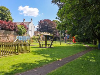 A playground with swings and a slide in an outdoor area