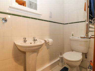 A bathroom with a pedestal sink and toilet at Bwthyn Ael Y Bryn in Criccieth