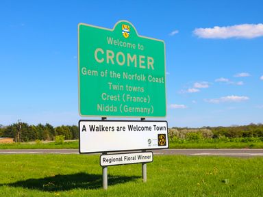A road sign welcoming visitors to Cromer with information about twin towns and walker friendly town status