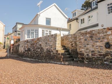 Stone steps and walls leading to white houses with multiple windows