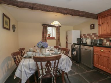 A kitchen with a dining table and appliances at Rose Cottage in Broughton-In-Furness