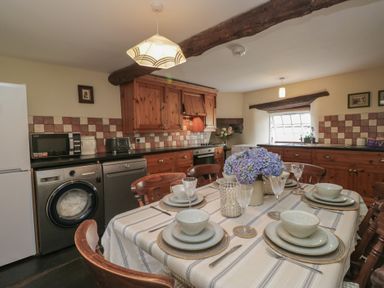 A kitchen with a table set for dining at Rose Cottage in Broughton-In-Furness
