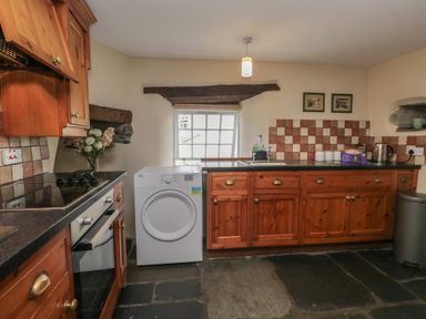 A kitchen with cabinets and appliances at Rose Cottage in Broughton-In-Furness