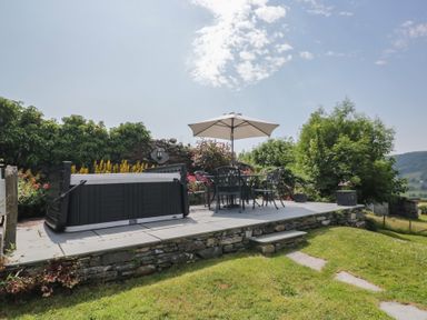 A garden with a hot tub and seating area at Rose Cottage in Broughton-In-Furness