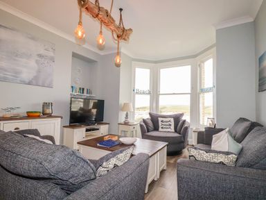 A living room with sofas and a television at Seashore House in Porth