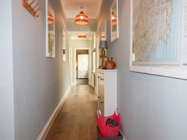 A hallway with mirrors and a coatrack at Seashore House in Porth