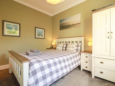 A bedroom with a bed and nightstand at Seashore House in Porth