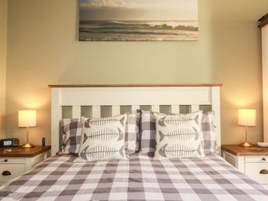 A bedroom with a bed and bedside lamps at Seashore House in Porth